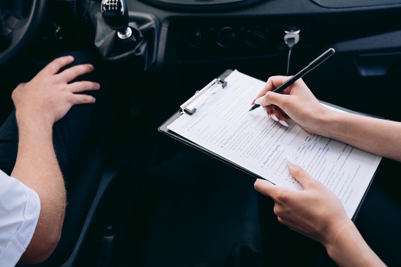 Professional completing detailed claim documentation inside a vehicle